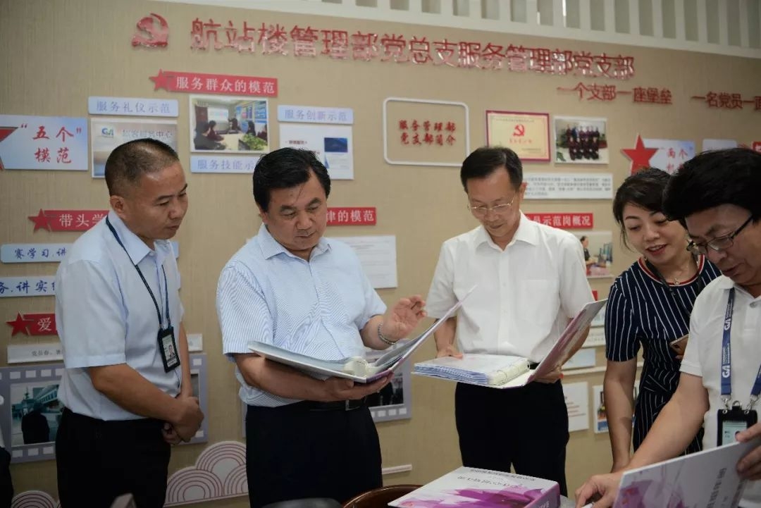 馮正霖觀摩重慶江北機場地服“心連心”班組建設(shè)材料。 中國民航報 陸二佳攝