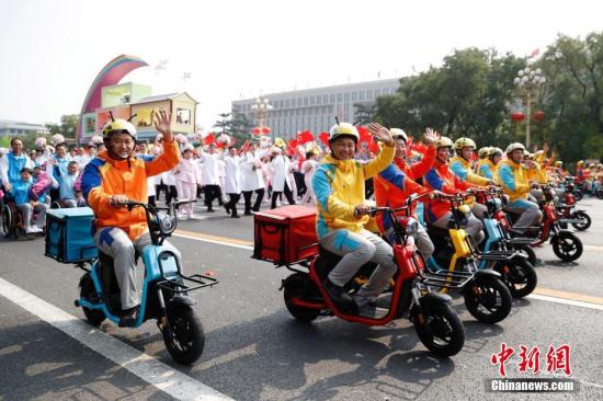 10月1日上午，慶祝中華人民共和國成立70周年大會(huì)在北京天安門廣場隆重舉行。圖為群眾游行中的“快遞小哥”。中新社記者 韓海丹 攝