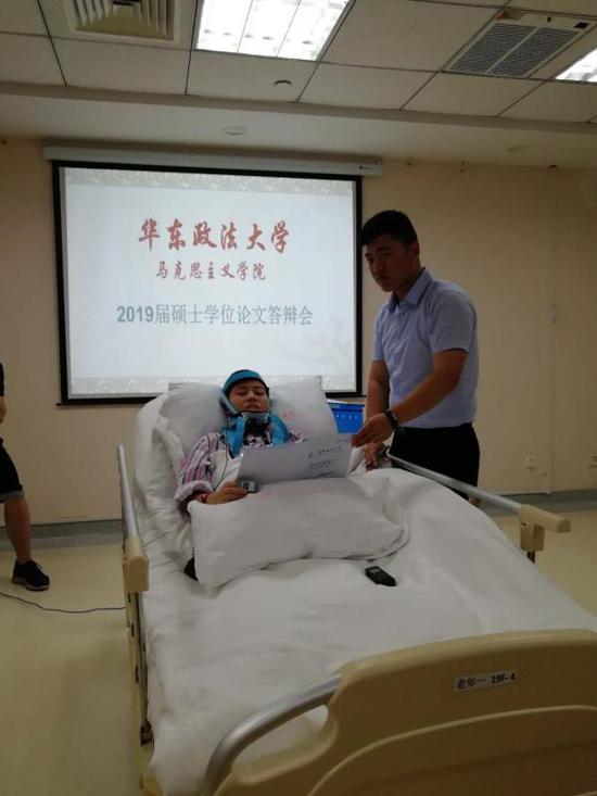 程艷芳正在進行答辯，弟弟程浩幫她舉著論文 受訪者供圖